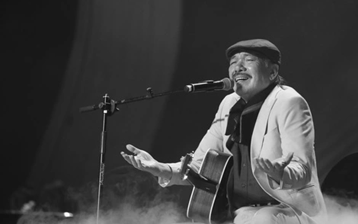 Hinh anh nhac si Tran Tien om dan guitar hat du ca